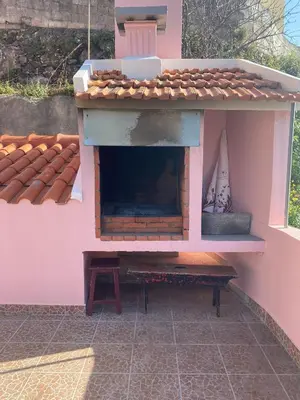 a playhouse with a fireplace in a pink house at Vivenda Ribeiro - Curral das Freiras in Curral das Freiras