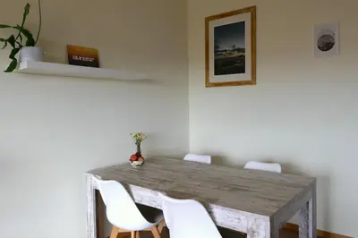 a wooden table with white chairs in a room at Panorama Apartment Sagres *Pool* in Sagres