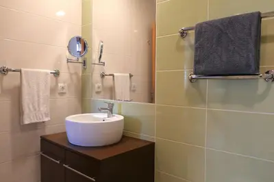 a bathroom with a sink and a mirror and towels at Panorama Apartment Sagres *Pool* in Sagres