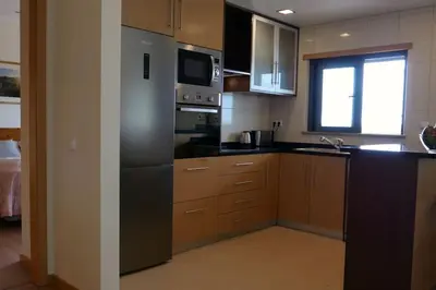 a kitchen with stainless steel appliances and a window at Panorama Apartment Sagres *Pool* in Sagres