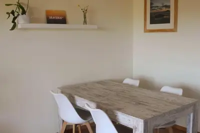 a dining room table with white chairs around it at Panorama Apartment Sagres *Pool* in Sagres