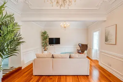 a living room with a white couch and a chandelier at Madeira Loft II - FREE CAR in Caniço