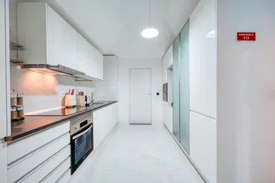 a kitchen with white cabinets and a counter at Madeira Loft II - FREE CAR in Caniço