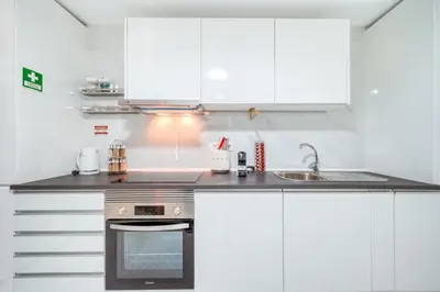 a kitchen with white cabinets and a sink at Madeira Loft II - FREE CAR in Caniço
