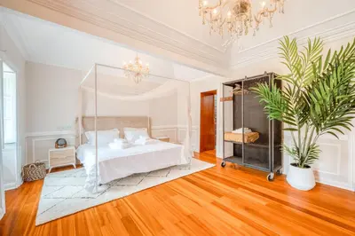 a bedroom with a white bed and a chandelier at Madeira Loft II - FREE CAR in Caniço