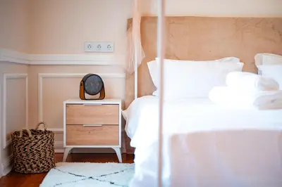 a bedroom with a bed and a clock on a night stand at Madeira Loft II - FREE CAR in Caniço