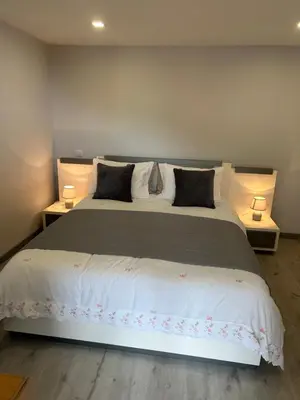 a bedroom with a large bed with two lamps at Tropical Garden in Arco da Calheta