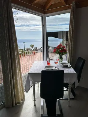 a dining table with a view of the ocean at Tropical Garden in Arco da Calheta