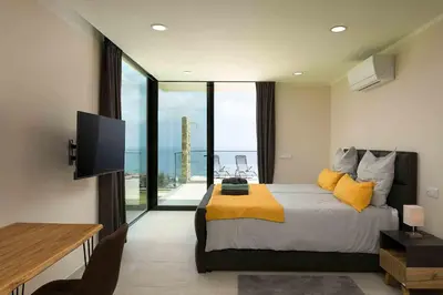 a bedroom with a large bed with a large window at Villa Ohana in Estreito da Calheta