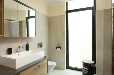 a bathroom with a white sink and a mirror at Villa Ohana in Estreito da Calheta