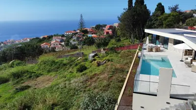 a house on a hill with a swimming pool at Villa Ohana in Estreito da Calheta