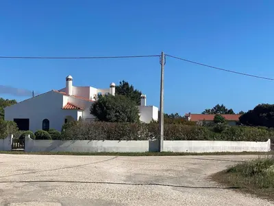 a white house on a hill behind a street at Villa Mourisca in Aljezur