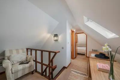 a living room with a staircase and a chair at Casa da Cebola by An Island Apart in Santa Cruz
