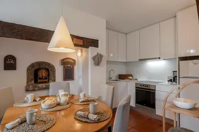 a kitchen and dining room with a wooden table at Casa da Cebola by An Island Apart in Santa Cruz