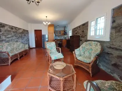 a living room with wicker chairs and a table at Terra Batista house in Porto da Cruz