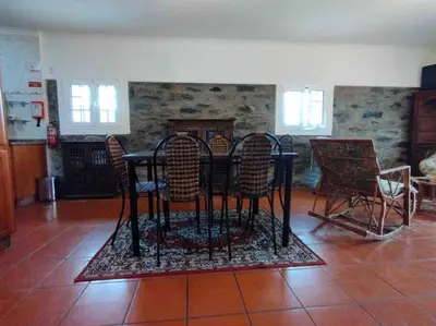 a dining room with a black table and chairs at Terra Batista house in Porto da Cruz
