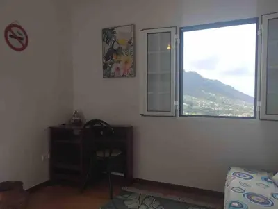 a bedroom with a desk and a window and a chair at Terra Batista house in Porto da Cruz