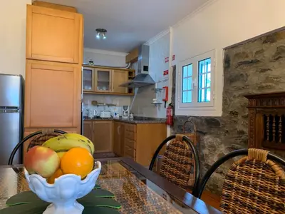 a kitchen with a bowl of fruit on a table at Terra Batista house in Porto da Cruz