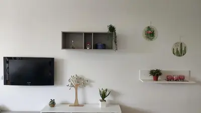 a living room with a tv on a white wall at Viewpoint Machico - Lovely Nature View in Machico
