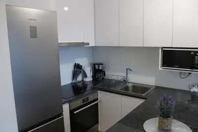 a small kitchen with white cabinets and a sink at Viewpoint Machico - Lovely Nature View in Machico