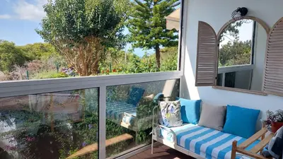 a balcony with a couch and a window at Viewpoint Machico - Lovely Nature View in Machico