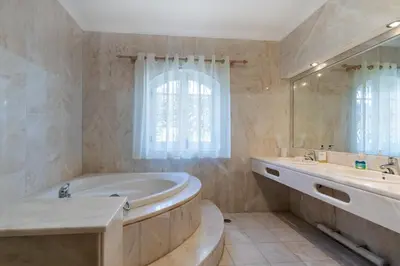 a bathroom with a tub and two sinks and a mirror at Casa Sapo Gordo in Luz