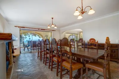 a dining room with a wooden table and chairs at Casa Sapo Gordo in Luz