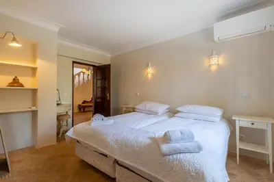 a bedroom with a large white bed with towels on it at Casa Sapo Gordo in Luz