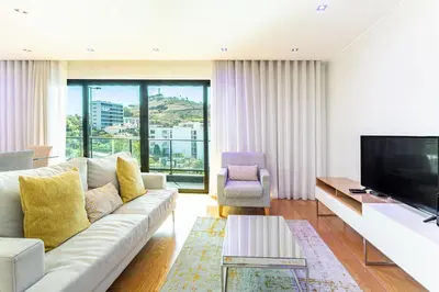 a living room with a couch and a tv at Leonor Seaview Apartment in Funchal