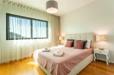 a bedroom with a large bed with a large window at Leonor Seaview Apartment in Funchal
