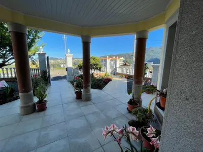 a porch with potted plants and a view of the mountains at Belle Vue in São Jorge