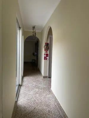 an empty hallway with a white wall and a chandelier at Belle Vue in São Jorge