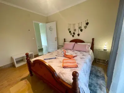 a bedroom with a large bed with pink pillows at Belle Vue in São Jorge