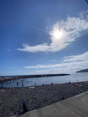 a group of people on a beach near the water at 2 bed room apartment , sea view, 10 minutes walk to the beach in Ribeira Brava