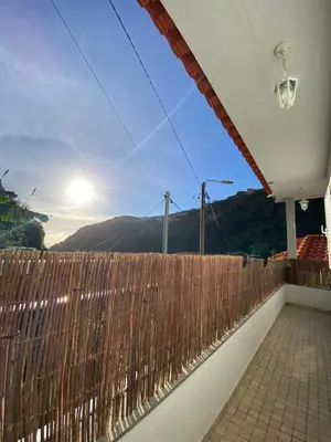 a wooden fence with the sun in the sky at 2 bed room apartment , sea view, 10 minutes walk to the beach in Ribeira Brava
