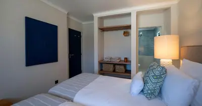 a bedroom with a white bed and a blue painting at Az Ribat Sea e Sun in Aljezur