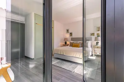 a bedroom with a bed and a glass door at Fort Bay Suite Apartments in Machico