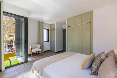 a bedroom with a large bed and a sliding glass door at Fort Bay Suite Apartments in Machico