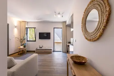 a living room with a mirror and a couch at Fort Bay Suite Apartments in Machico