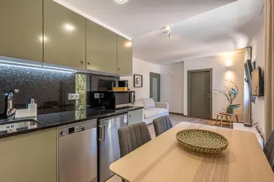 a kitchen and a dining room with a table and a kitchen gmaxwell gmaxwell at Fort Bay Suite Apartments in Machico