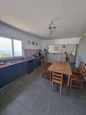 a kitchen and dining room with a table and chairs at Casa agapanthe in Estreito da Calheta