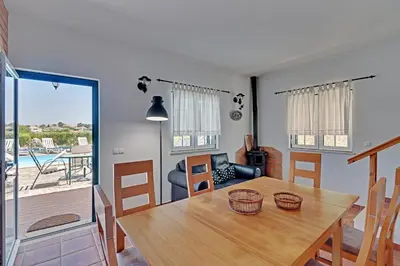 a dining room with a table and a view of a pool at Casa Lady D'Avila in Aljezur