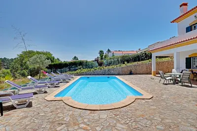 a swimming pool with lounge chairs and a house at Casa Lady D'Avila in Aljezur
