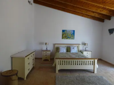a bedroom with a bed and two night stands and a table at Casa Brisa Suave in Aljezur