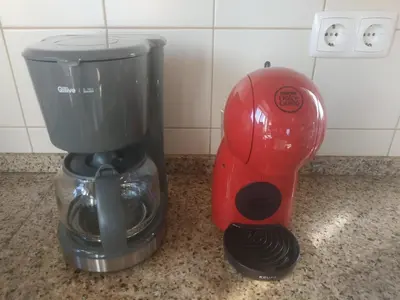 a red blender sitting next to a coffee maker on a counter at Casa Brisa Suave in Aljezur