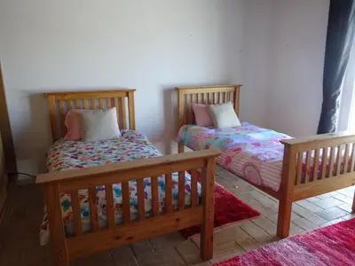 two wooden beds in a room with a rug at Casa Brisa Suave in Aljezur