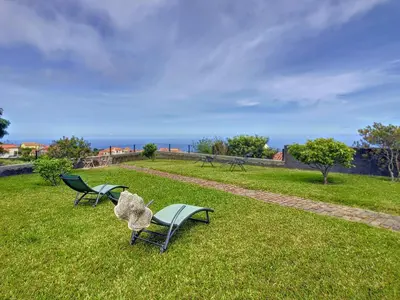 two chairs and a bench on a grass field at Casa DaSa by LovelyStay in Salão