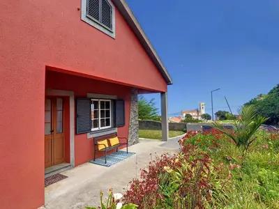 a red building with a bench next to a door at Casa DaSa by LovelyStay in Salão
